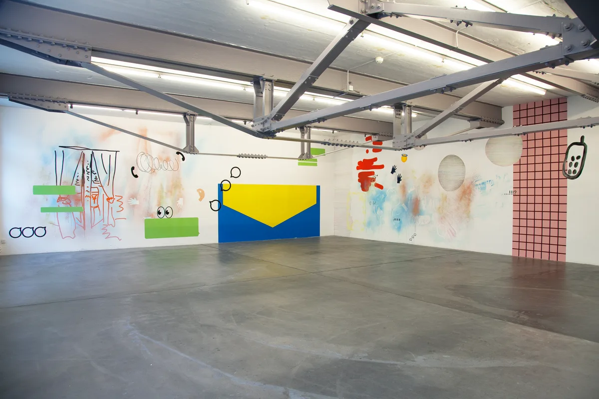 Man sieht Kunst an Wänden in einer Halle.